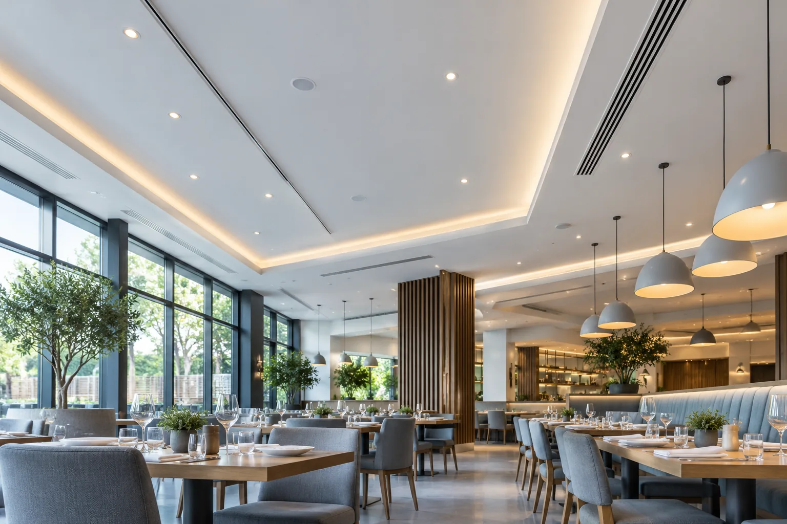 Empty modern restaurant dining room with pendant lights and a clean ceiling